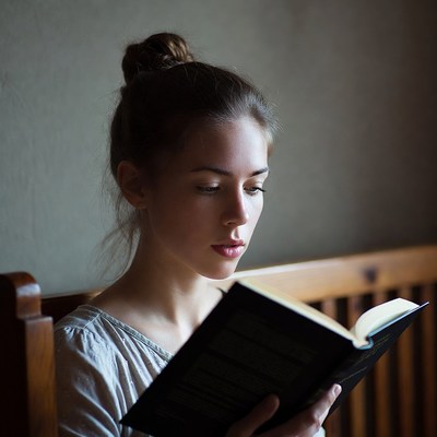 Woman reading book on bed