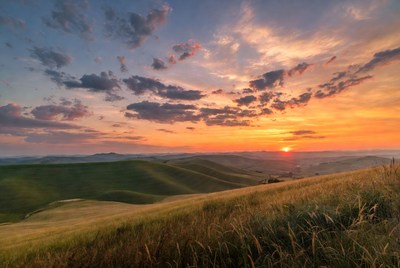 Sunset over rolling green hills