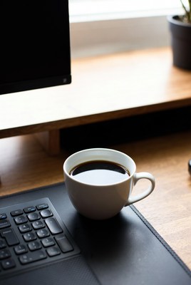 White mug of coffee on desk
