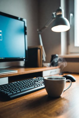 Coffee cup on desk by computer