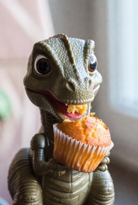 Toy dinosaur eating muffin