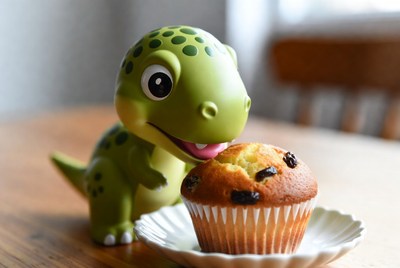 Cute green T-Rex eating muffin