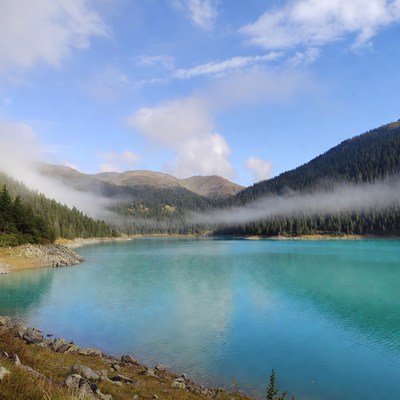Turquoise Mountain Lake with Foggy Forests