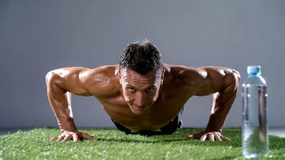 Muscular man doing pushups on grass