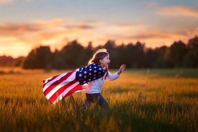 Girl running with American flag cape