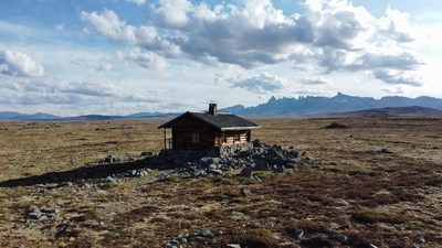Log cabin on rocky tundra mountains