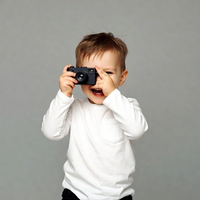 Toddler boy holding camera