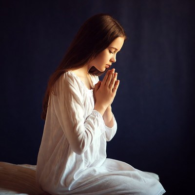 Girl praying with hands clasped