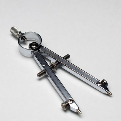 Silver drafting compass on white