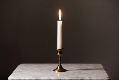 Lit White Candle in Brass Holder
