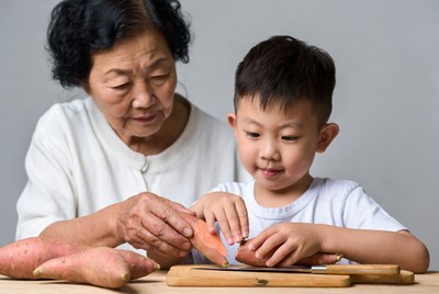 Grandmother and boy cutting sweet potatoes