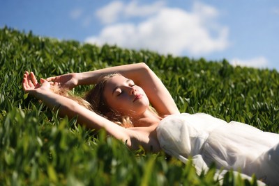 Blonde woman lying in green grass