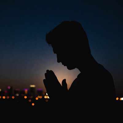 Silhouette of man praying at night
