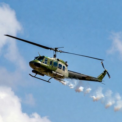 Green military helicopter flying in sky