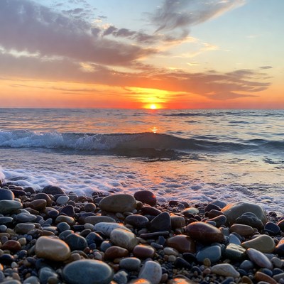 Sunset over pebbly beach