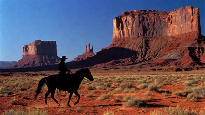 Cowboy riding horse in Monument Valley