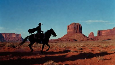 Cowboy riding horse in desert silhouette
