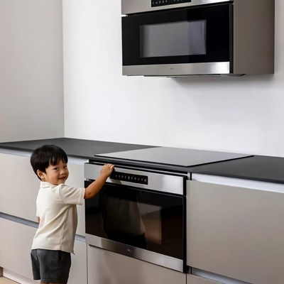 Asian boy touching modern kitchen oven