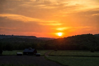 Barn in field at sunset