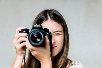 Young woman looking through camera