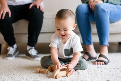 Asian baby playing with wooden cars
