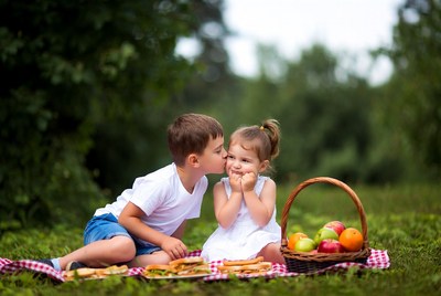 Boy kissing girl during picnic