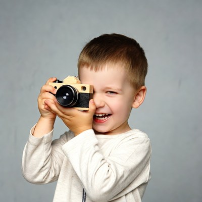 Boy playing with wooden toy camera