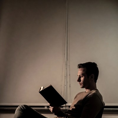 Man reading book by window