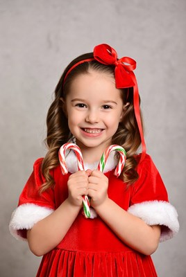 Girl holding candy canes in red dress