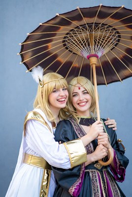 Two women in cosplay holding parasol