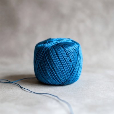 Blue yarn ball with trailing thread