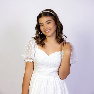 Smiling girl in white polka dot dress