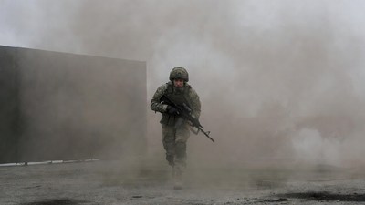 Soldier running with rifle in smoke