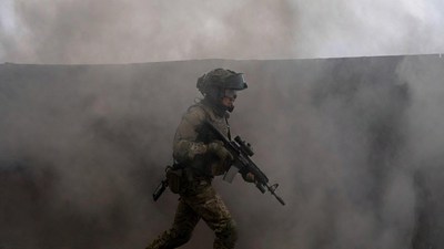 Soldier advancing through smoke with rifle