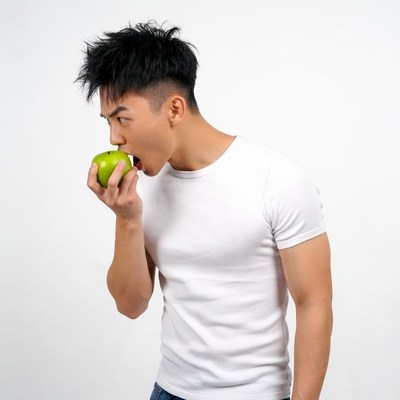 Asian man eating green apple
