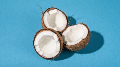 Three split coconuts on blue background