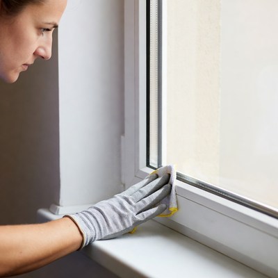 Woman cleaning window with rag