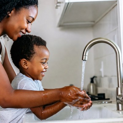 African-American mother teaching toddler handwashing