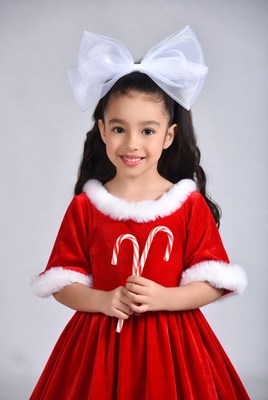 Girl in red Santa dress holding candy canes