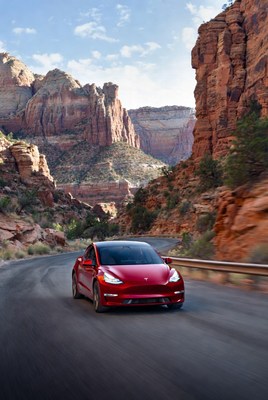Red Tesla driving Zion canyon road