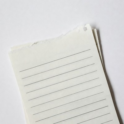 Stack of torn lined paper sheets