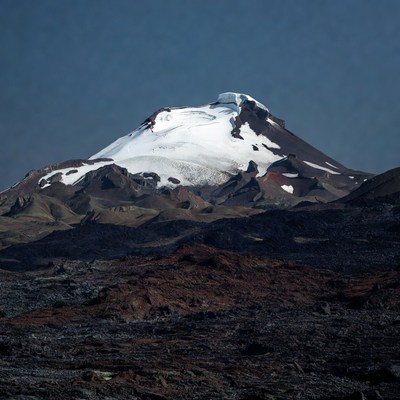 Snow-capped volcano with red lava flows