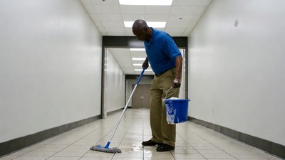 African-American man mopping hallway floor