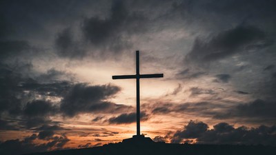 Silhouette Cross on Hill at Sunset