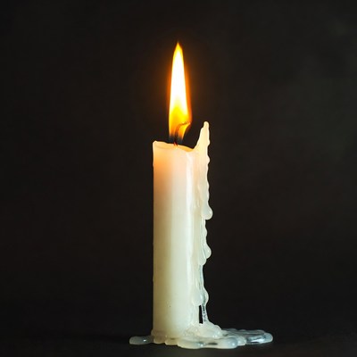 Burning White Candle with Wax Drips
