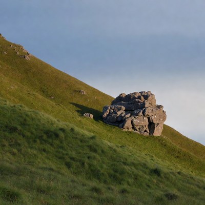 Rock Formation on Grassy Hillside