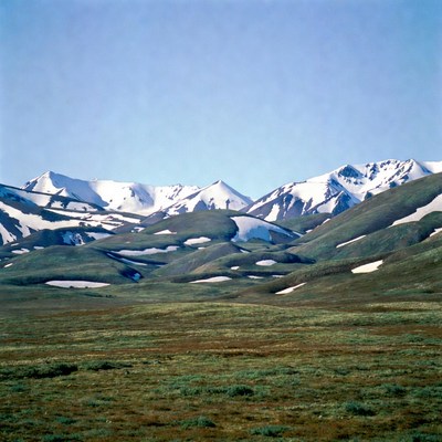 Snow-capped mountains over green valley