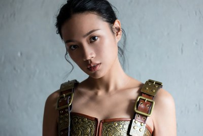 Asian woman in ornate leather harness