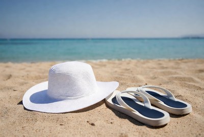 White straw hat and flip flops on beach
