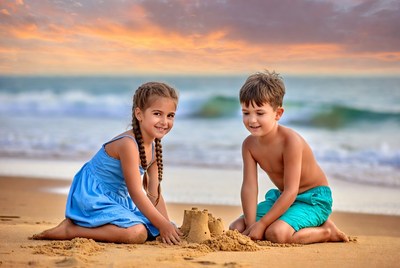Boy and Girl Building Sandcastle on Beach
